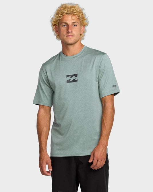 Image of a model wearing Tops. Product name - Billabong Mens All Day Wave Short Sleeve Rash Vest Sea Blue in Sea Blue colour by brand - Billabong
