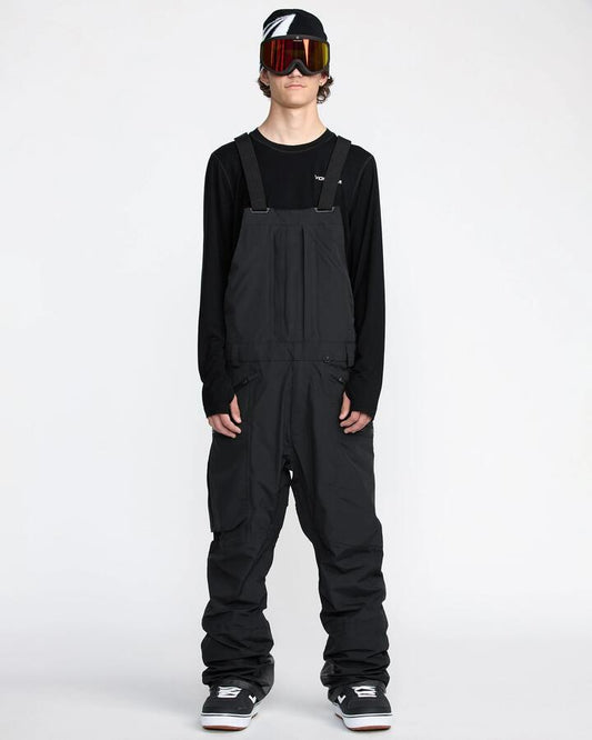 Image of a model wearing Pants. Product name - Volcom Mens Rain Gore-Tex Bib Snow Pants Black in Black colour by brand - Volcom