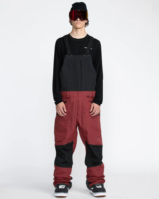 Image of a model wearing Pants. Productname: Volcom Mens Rain Gore-Tex Bib Snow Pants Burnt Red - in Burnt Red colour by brand - Volcom