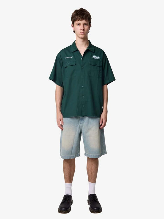 Image of a model wearing Tops. Productname: Worship Department Short Sleeve Workshirt in Hunter Green colour by brand - Worship