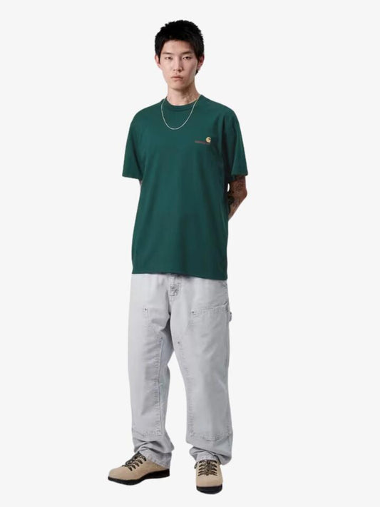 Image of a model wearing Shorts. Productname: Carhartt Wip Short Sleeve American Script T-Shirt in Dark Fir colour by brand - Carhartt Wip