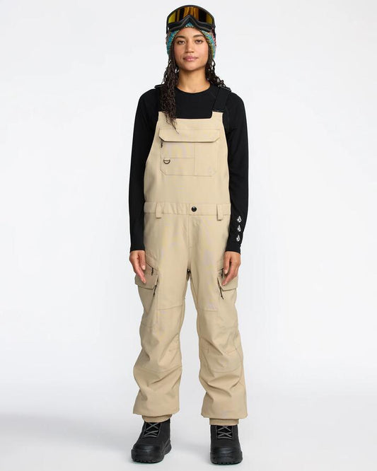 Image of a model wearing Pants. Product name - Volcom Womens Creston 3D Stretch Bib Overall Oatmeal in Oatmeal colour by brand - Volcom