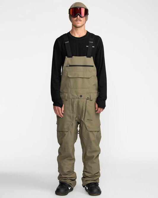 Image of a model wearing Pants. Productname: Volcom Mens Roan Bib Snow Pants Military - in Military colour by brand - Volcom