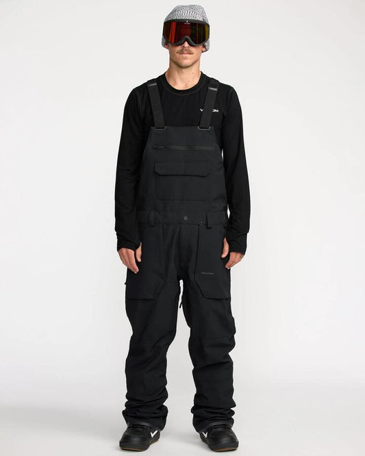 Image of a model wearing Pants. Productname: Volcom - Mens Roan Bib Snow Pants - Black - in Black colour by brand - Volcom