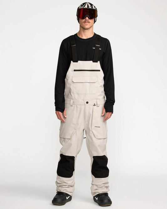 Image of a model wearing Pants. Productname: Volcom - Mens Roan Bib Snow Pants - Stone - in Stone colour by brand - Volcom