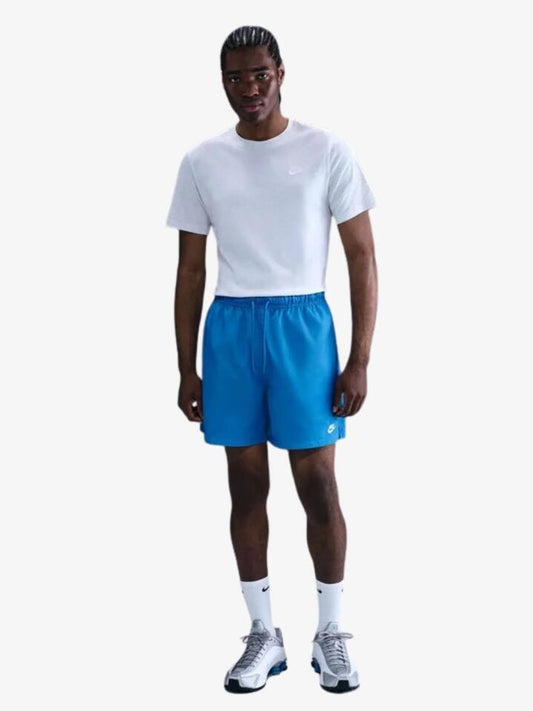 Image of a model wearing Shorts. Productname: Nike Men's Nike Club Woven Flow Short in Lt Photo Blue/White colour by brand - Nike