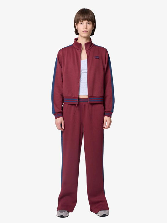 Image of a model wearing Pants. Productname: New Balance Post Season Pique Track Pants in Monarch Burgundy colour by brand - New Balance