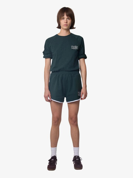 Image of a model wearing Tops. Productname: West Hollywood Sweat Club American Sportswear Raglan Long Sleeve Tee in BOTTLE colour by brand - West Hollywood Sweat Club