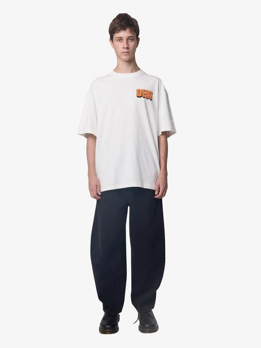 Image of a model wearing Tops. Productname: Deus Primitive Fuel Tee in Vintage White colour by brand - Deus