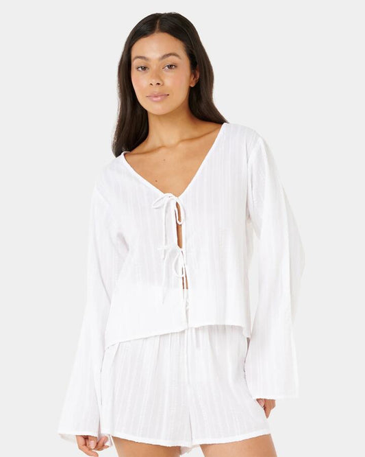 Image of a model wearing Tops. Productname: rip Curl - Womens Haze Tie Front Long Sleeve Shirt - White - in White colour by brand - rip Curl