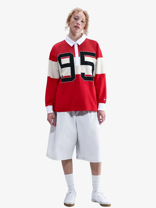 Image of a model wearing Tops. Productname: Nike NSW Street Long Sleeve Graphic Polo in Unvrsty Rd/Lt Orwd Brn/Wht/Sai colour by brand - Nike