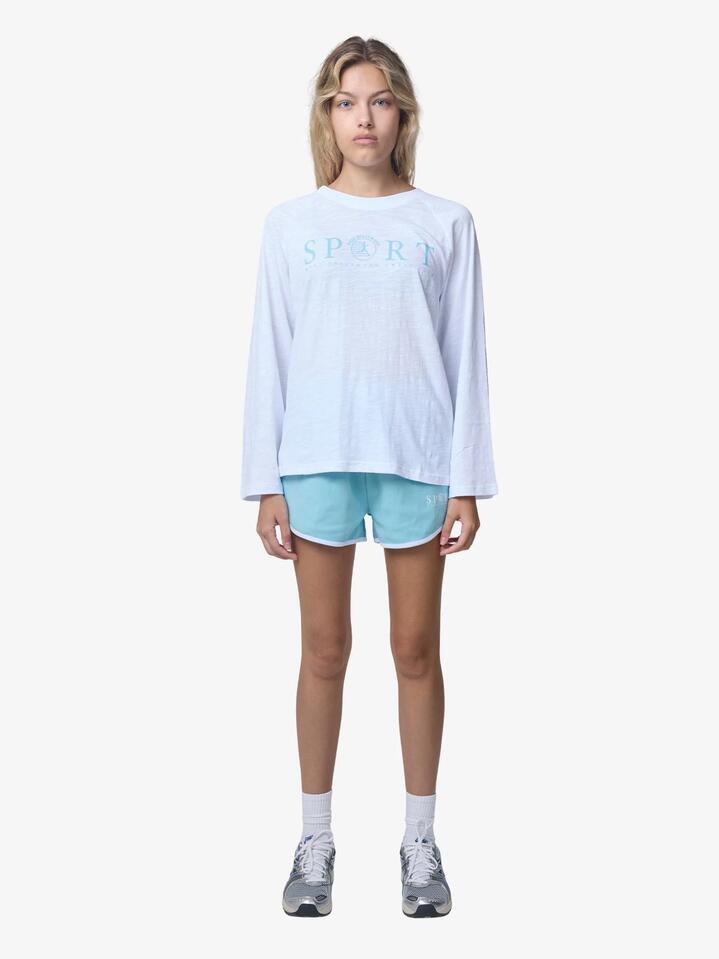 Image of a model wearing Outerwear. Productname: West Hollywood Sweat Club Sport Scalloped Sweatshorts in Mid Blue/White colour by brand - West Hollywood Sweat Club