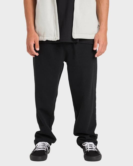 Image of a model wearing Pants. Product name - Billabong Mens Spec 73 Trackpants Black in Black colour by brand - Billabong