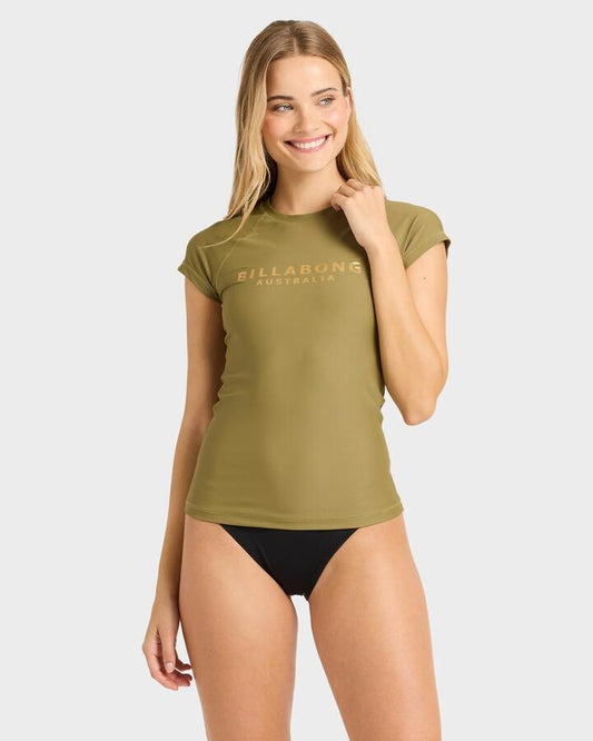 Image of a model wearing Tops. Productname: billabong Womens Society Foil Short Sleeve Rash Vest Dark Olive - in Dark Olive colour by brand - Billabong