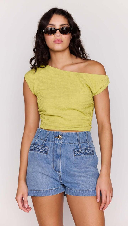 Image of a model wearing Pants. Product name - High Waisted Cotton Blend Denim Short in Mid Blue colour by brand - MINKPINK