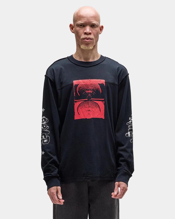 Image of a model wearing Tops. Product name - Former Mens Immerse Long Sleeve T-Shirt Black in Black colour by brand - Former