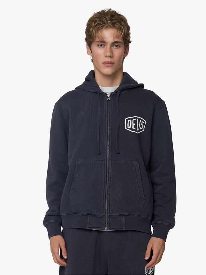 Image of a model wearing Outerwear. Productname: Deus Shield Garment Dyed Zip Hoodie in Black colour by brand - Deus