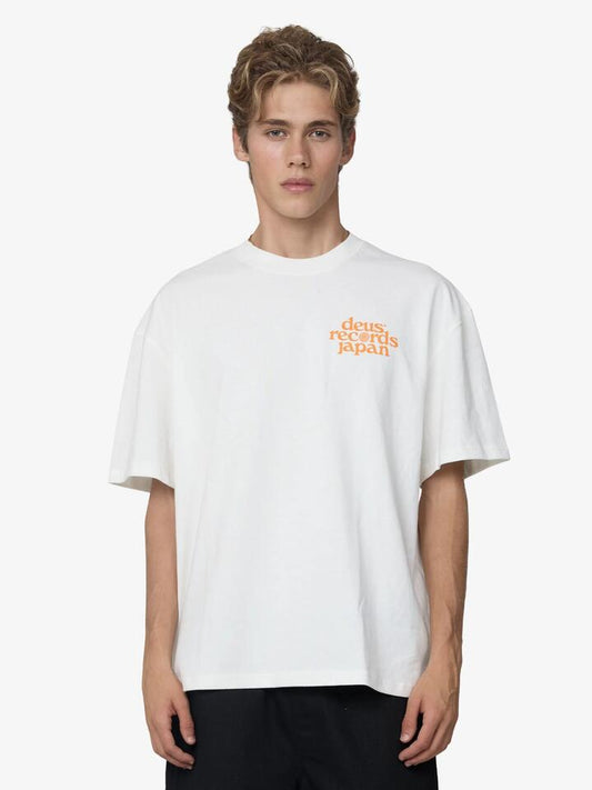 Image of a model wearing Tops. Productname: Deus Reverse Strata Tee in Vintage White colour by brand - Deus