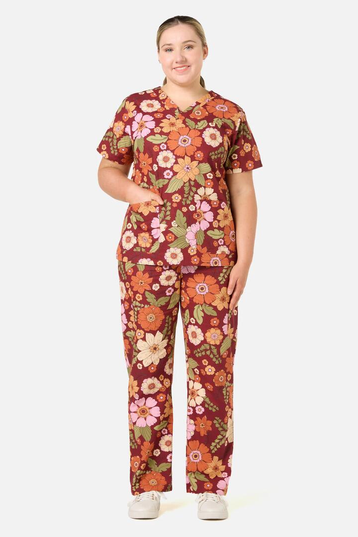 Image of a model wearing Uniforms & Workwear. Productname: Brandy Floral Scrub Set in Rust colour by brand - Scrubs With Love