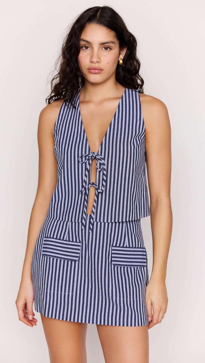 Image of a model wearing Skirts. Product name - Pinstripe Tie Front Vest Top in Blue Stripe colour by brand - MINKPINK
