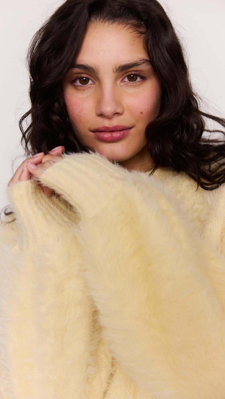 Image of a model wearing Tops. Product name - Butter Yellow Fluffy Knit Jumper in Butter colour by brand - MINKPINK