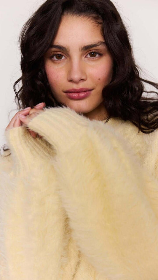 Image of a model wearing Tops. Product name - Butter Yellow Fluffy Knit Jumper in Butter colour by brand - MINKPINK