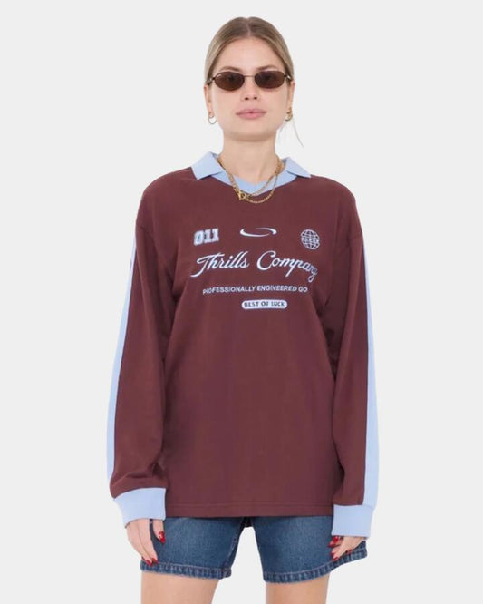 Image of a model wearing Tops. Product name - Thrills Womens Game Day Polo Long Sleeve Shirt Bitter Chocolate in Bitter Chocolate colour by brand - Thrills