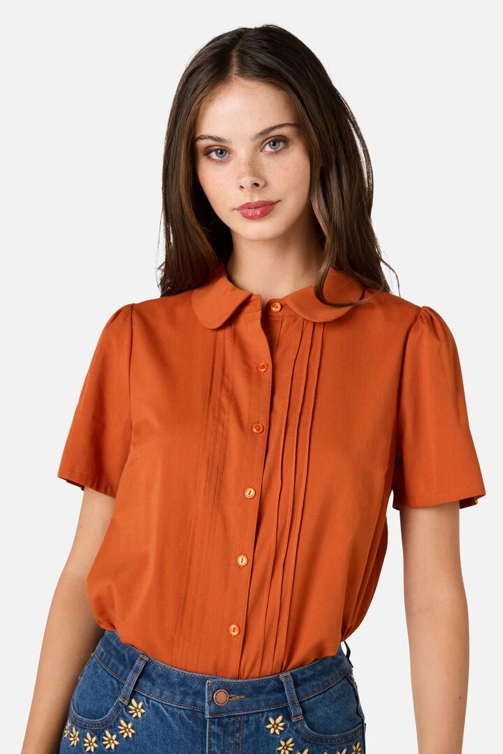 Image of a model wearing Tops. Productname: Lizzy Short Sleeve Blouse in Rust colour by brand - Princess Highway