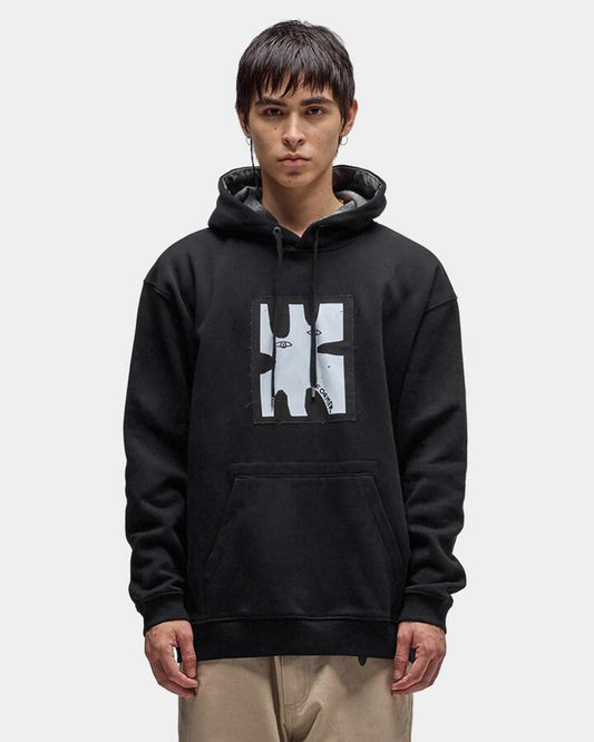 Image of a model wearing Outerwear. Product name - Former Mens Enigma Patch Pullover Hoodie Black in Black colour by brand - Former