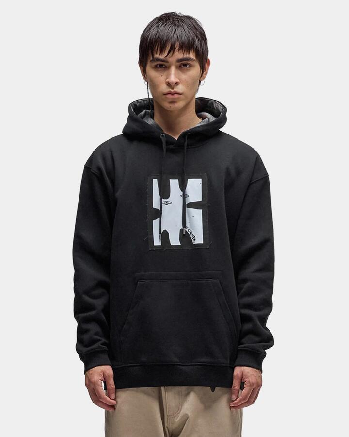 Image of a model wearing Outerwear. Product name - Former Mens Enigma Patch Pullover Hoodie Black in Black colour by brand - Former