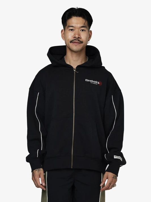 Image of a model wearing Outerwear. Productname: Reebok Classics Zip Through Hoodie in Black colour by brand - Reebok