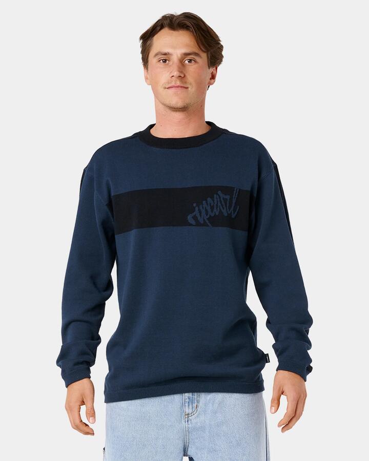 Image of a model wearing Tops. Product name - Rip Curl Mens Panel Beater Knit Crew Neck Dark Navy in Dark Navy colour by brand - Rip Curl