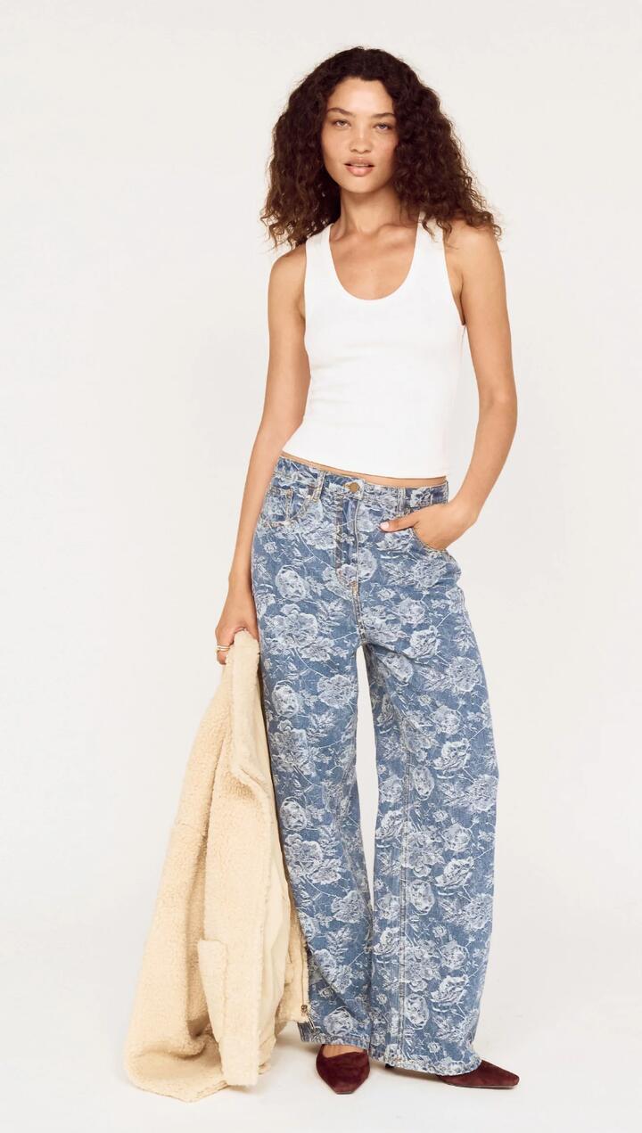 Image of a model wearing Pants. Product name - Mid Rise Floral Denim Wide Leg Jeans in Mid Indigo Wash colour by brand - MINKPINK