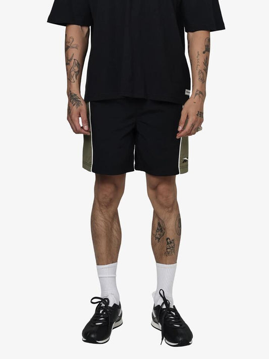 Image of a model wearing Shorts. Productname: Reebok Classics Woven Shorts in Black/Legacy Green colour by brand - Reebok