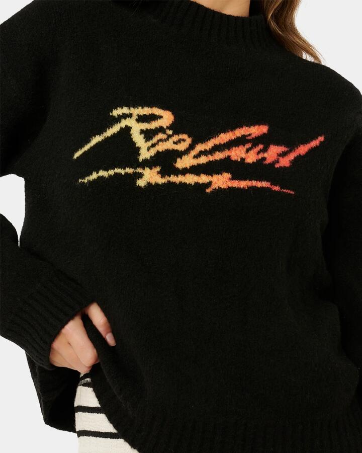 Image of a model wearing Tops. Product name - Rip Curl Womens Rip Curl Paradise Knit Crew Neck Black in Black colour by brand - Rip Curl