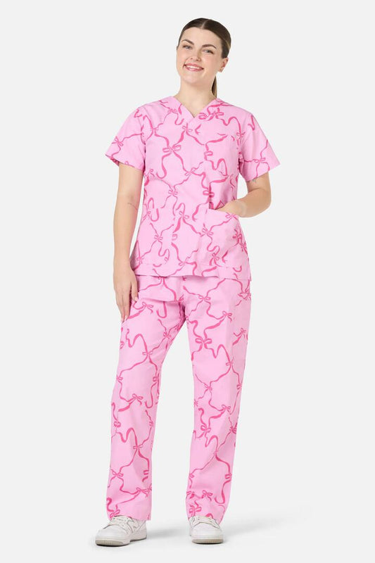 Image of a model wearing Uniforms & Workwear. Productname: Pink Bows Scrub Set in Pink colour by brand - Scrubs With Love