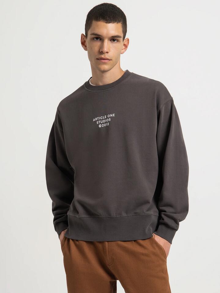 Image of a model wearing Outerwear. Productname: Article One Studio Logo Sweater in Washed Black colour by brand - Article One