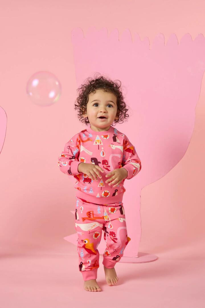 Image of a model wearing Pants. Product name - Funky Birds Baby Track Pant in Pink colour by brand - Gorman