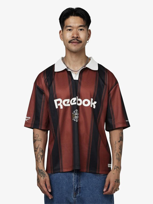 Image of a model wearing Tops. Productname: Reebok Classics Ss Jersey in Rust/Black colour by brand - Reebok