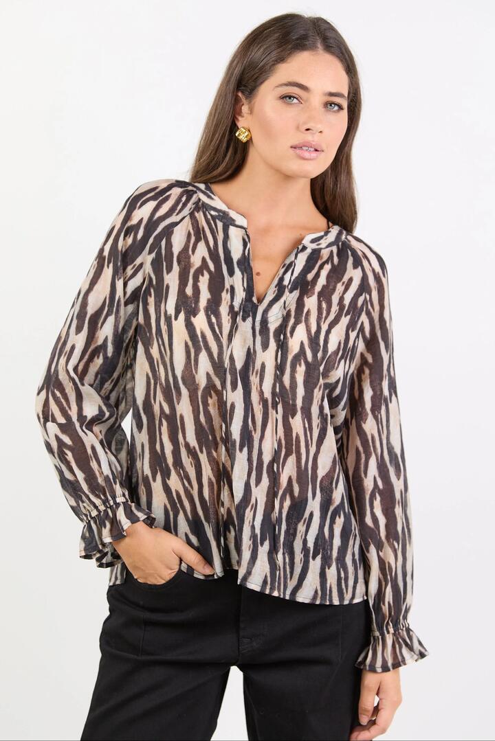 Image of a model wearing Tops. Product name - Woodland Black Zebra Tie Neck Flounce Long Sleeve Top in Black Zebra colour by brand - By Rosa.