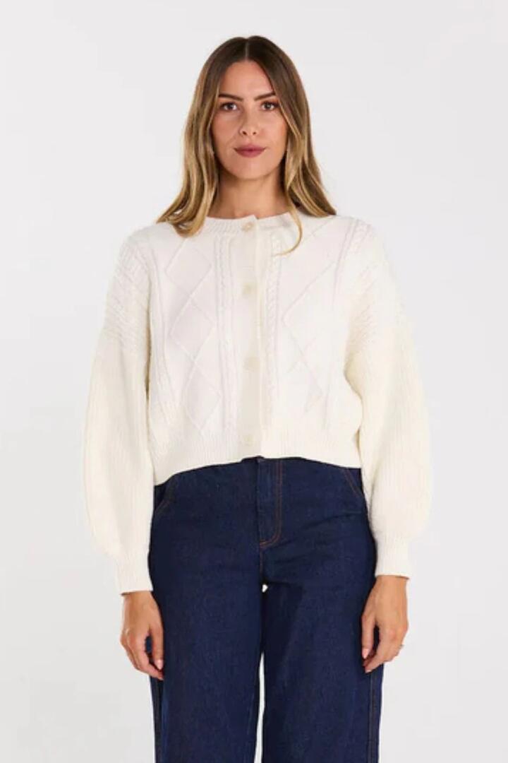 Image of a model wearing Outerwear. Product name - Flourish Milky Bar Cable Knit Cardigan in Cream colour by brand - Thing Thing