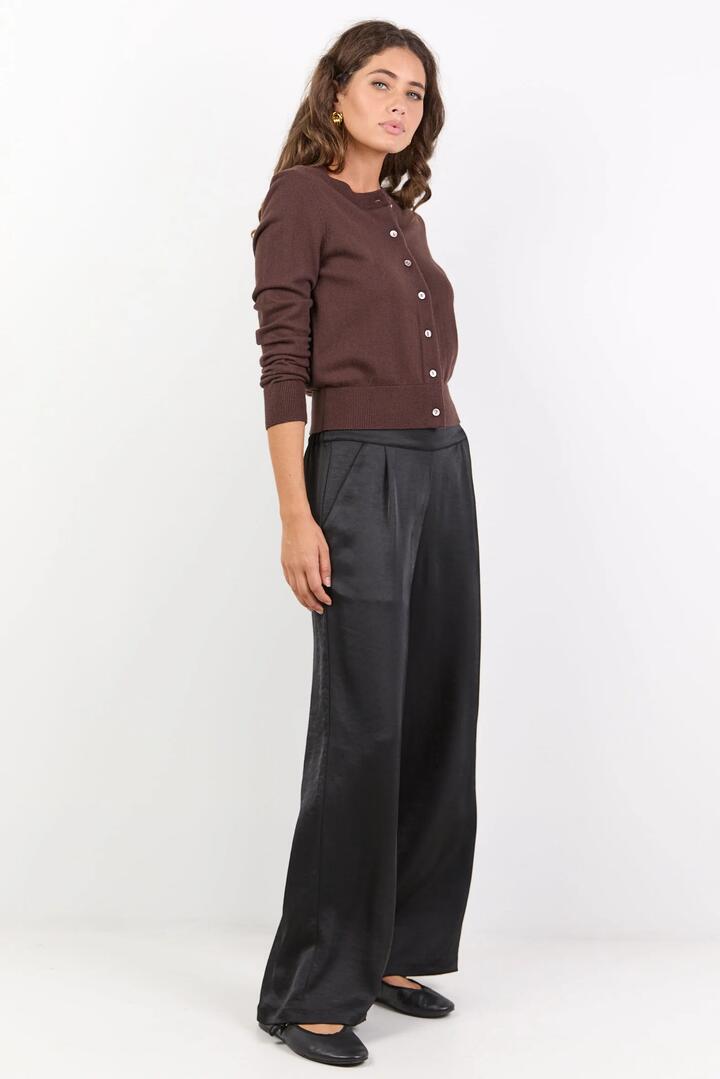 Image of a model wearing Pants. Product name - Grandeur Black Satin Elastic Back Wide Leg Pants in Black Satin colour by brand - By Rosa.