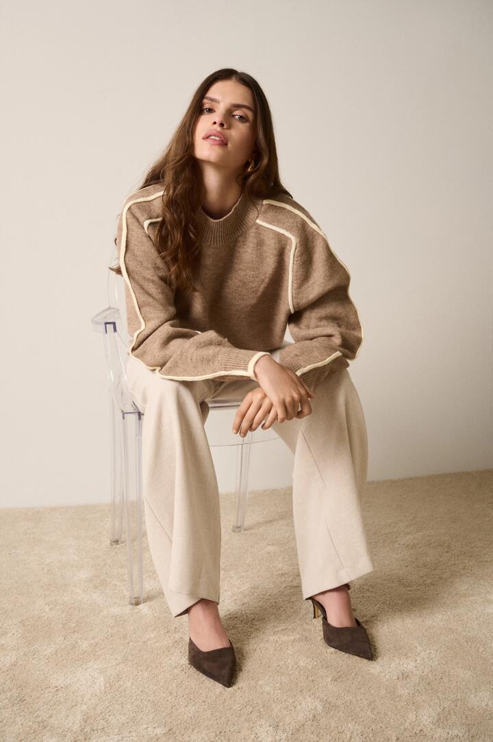 Image of a model wearing Outerwear. Product name - Getaway Mocha Contrast Ivory Piping Knit Sweater in Brown colour by brand - Esmaee