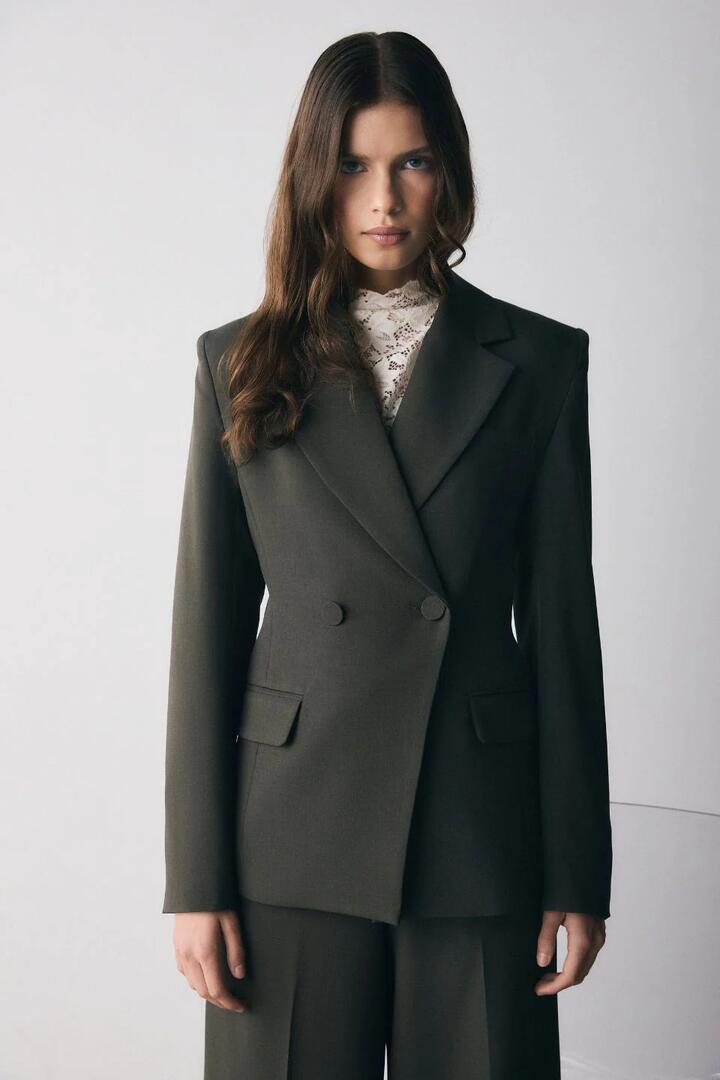 Image of a model wearing Outerwear. Product name - Symmetry Dark Olive Tailored Blazer in Olive colour by brand - Esmaee