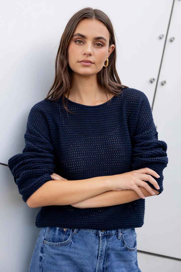 Image of a model wearing Outerwear. Product name - Dawn Ink Crochet Knit Jumper in Ink colour by brand - RE:UNION Label