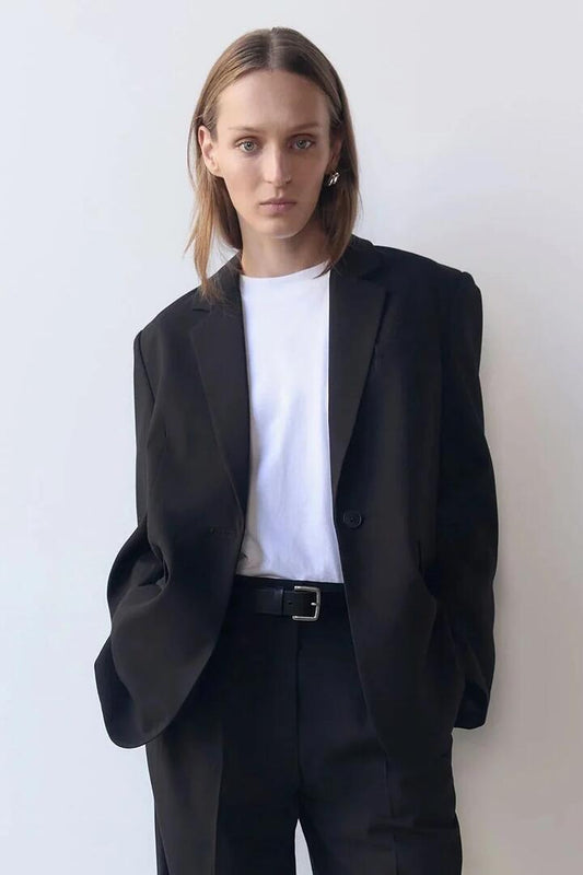 Image of a model wearing Outerwear. Product name - Orla Black Relaxed Blazer in Black colour by brand - Nude Lucy