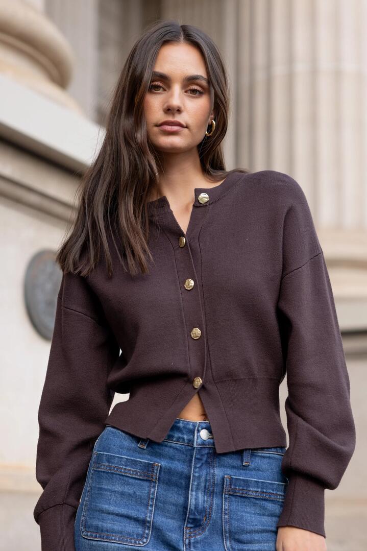 Image of a model wearing Outerwear. Product name - Hallmark Chocolate Crewneck Cardigan in Chocolate colour by brand - Ivy + Jack
