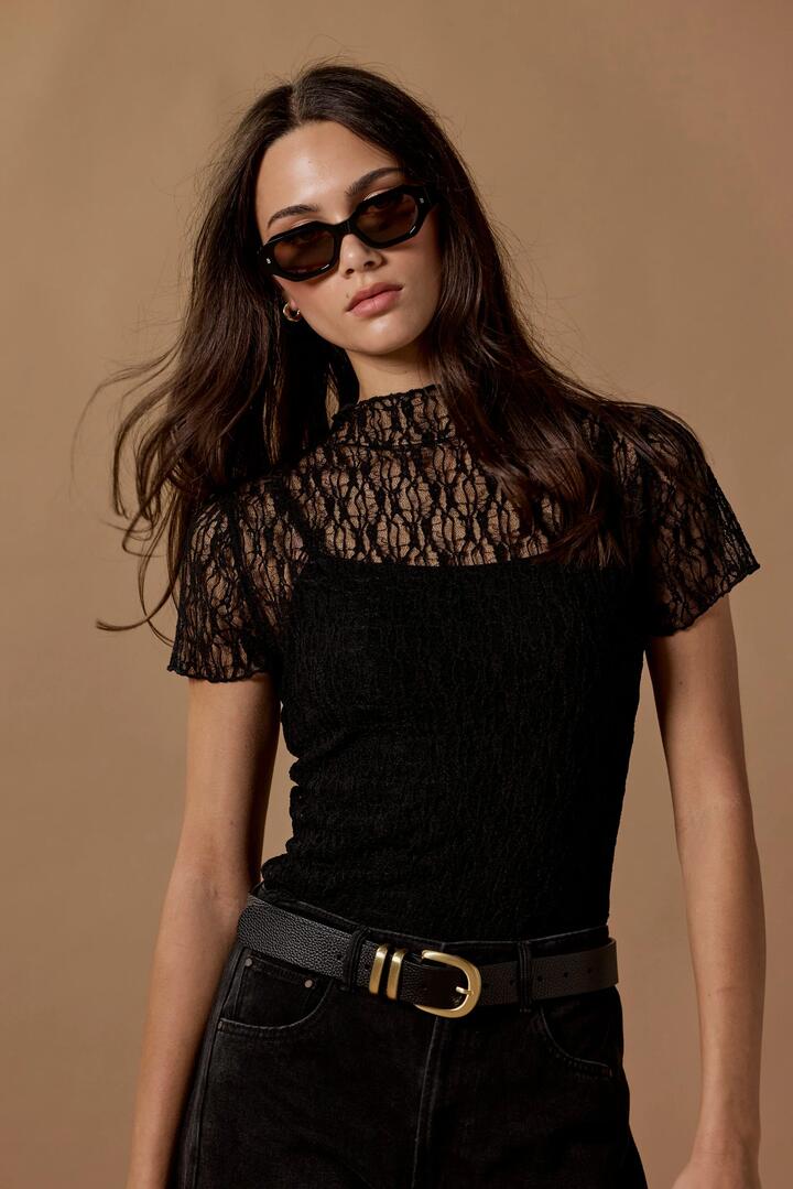 Image of a model wearing Tops. Product name - Providing Black Lace Short Sleeve Top in Black colour by brand - Among the Brave