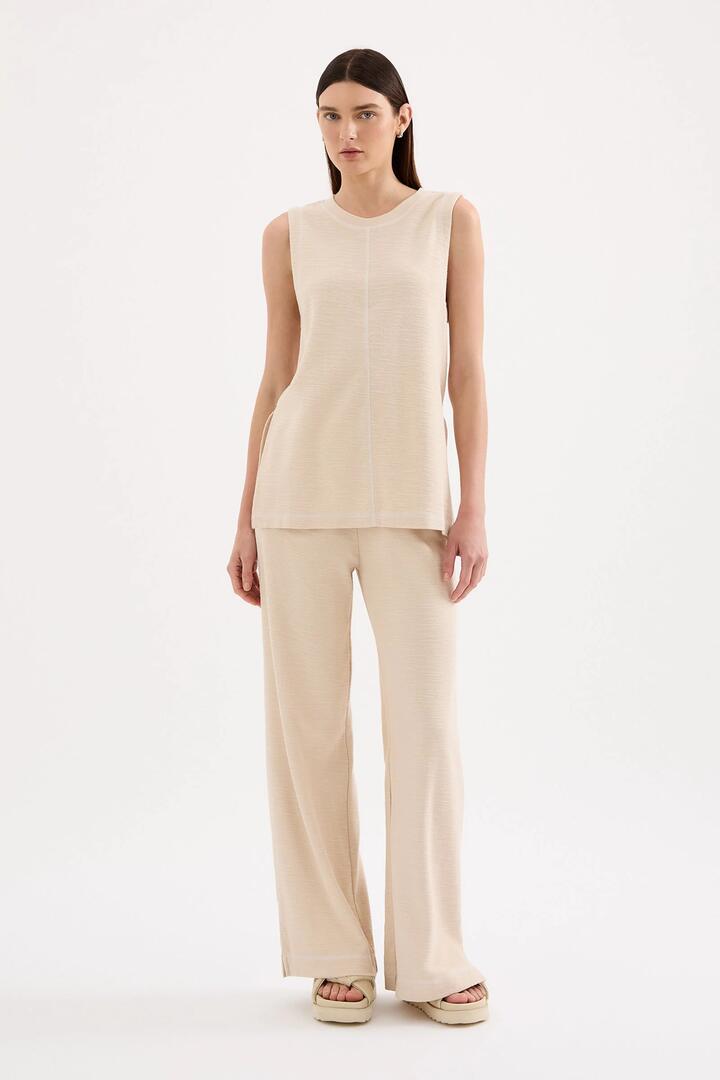 Image of a model wearing Pants. Product name - Sutton Cream Cotton Pant in Cream colour by brand - Nude Lucy