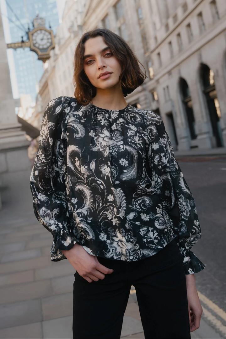 Image of a model wearing Tops. Product name - Briefly Black Scrolling Foliage Frill Sleeve Crew Neck Top in Black Scrolling Foliage colour by brand - Ivy + Jack